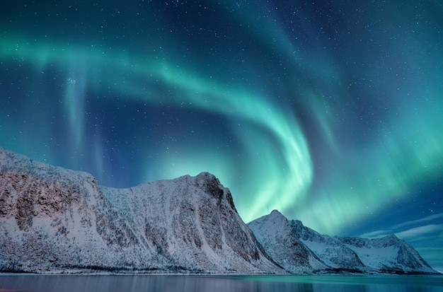 Aurora borealis in Norway Green northern lights above mountains Night winter landscape with aurora Natural phenomenon background in Norway