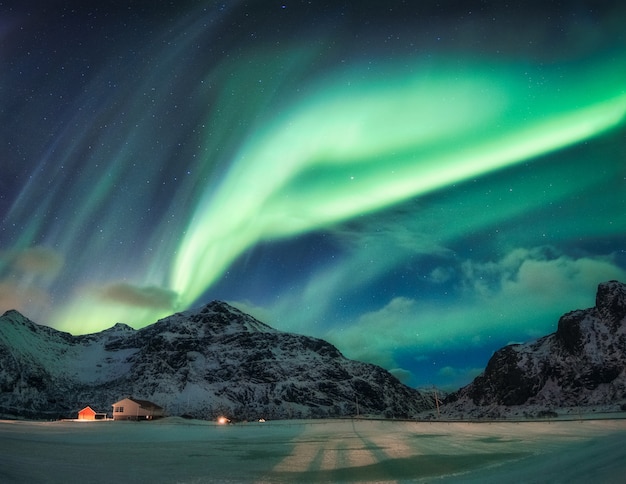 Aurora Borealis of noorderlicht over besneeuwde berg op poolcirkel in Flakstad op de Lofoten-eilanden