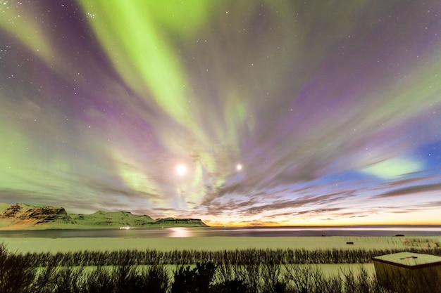 Photo aurora borealis over sea against sky at night