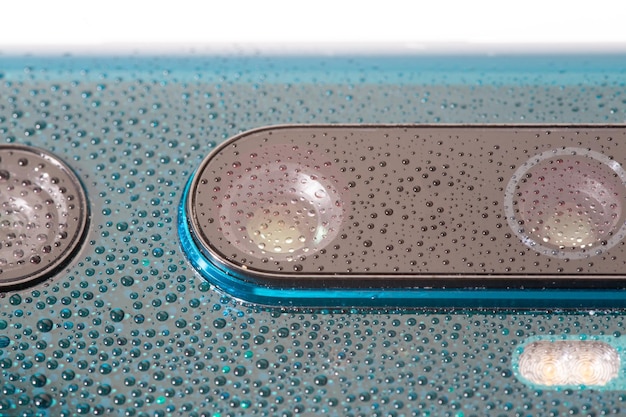 작은 물방울로 덮인 오로라 녹색 진주 전화 카메라 렌즈는 선택적인 초점과 흐림 효과가 있는 클로즈업