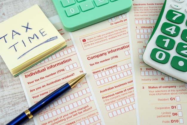 Australian annual corporate tax form with pen and calculator on desk financial concept