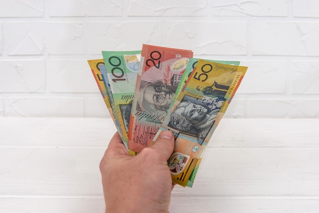 Photo australian dollar banknotes in hand giving for exchange