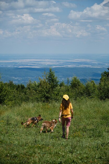 Australian and German Shepherds with girl owner on hike in summer Travel with pets