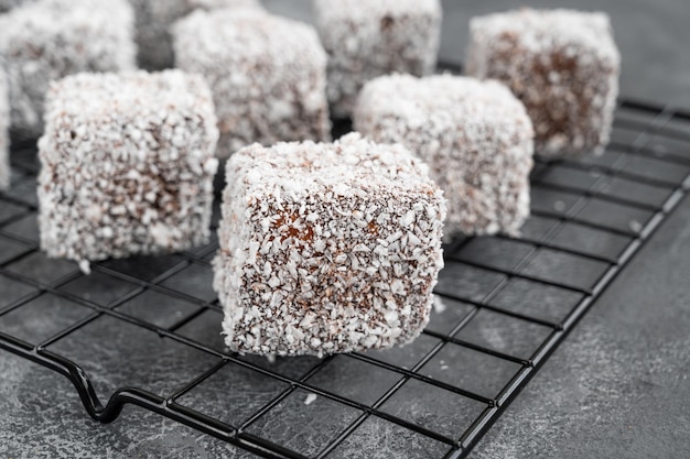 Australian Lamington cake in chocolate glaze and coconut flakes on a gray concrete background