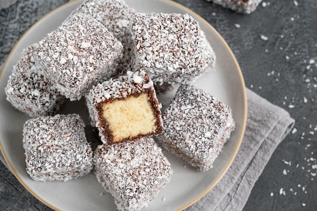 Australian Lamington cake in chocolate glaze and coconut flakes with a cup of tea Selective focus