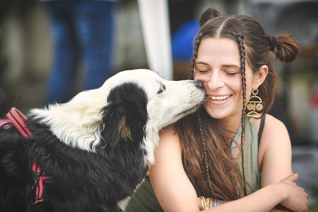 写真 オーストラリアン・シェパードの犬が若い女の子にキス