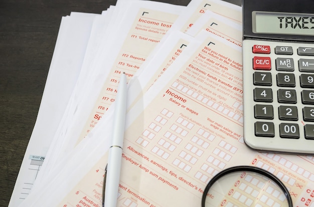 Australian tax forms with  calculator and  pen