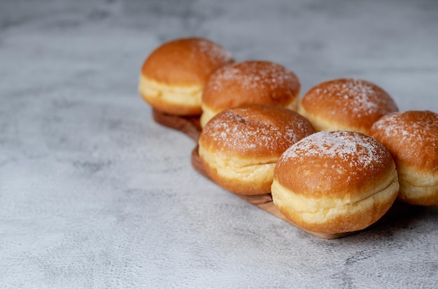 Австрийские и немецкие пончики или krapfen Faschingskrapfen berliner со сливками на сером фоне