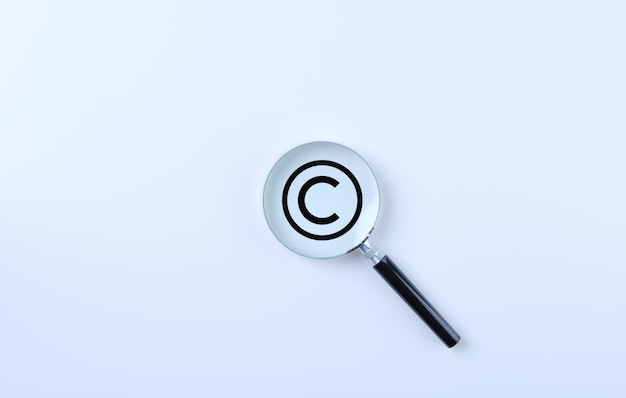 Auteursrechtenbescherming en patentenconcept Vergrootglas vergroot het auteursrechtensymbool op een witte achtergrond Auteursrechtensymbool Intellectuele eigendom Patentbescherming Registreer handelsmerkmerk