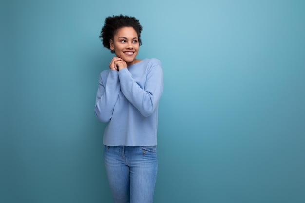 Authentic american brunette woman with curly hair rejoices against the background with copy space