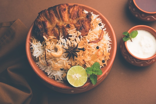 Authentic Fish Biryani served in a white plate over white background, selective focus