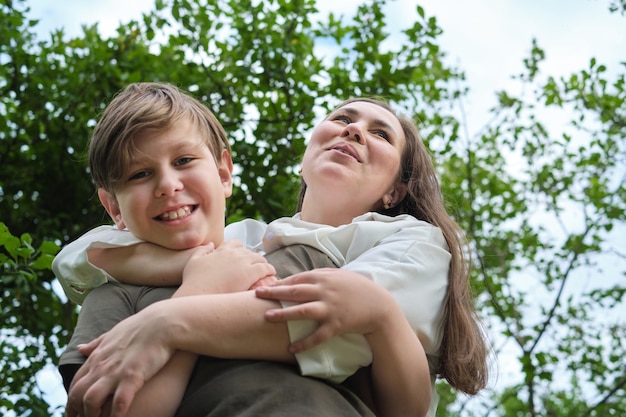 Authentic image from a garden photoshoot capturing a mother and her preteen son in a genuine laugh