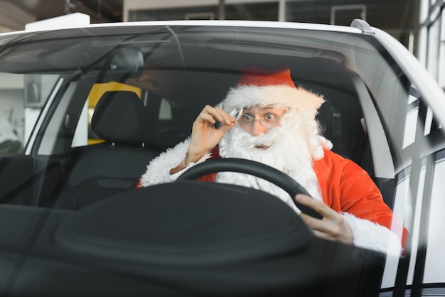 Authentic Santa Claus driving his modern car, outdoors