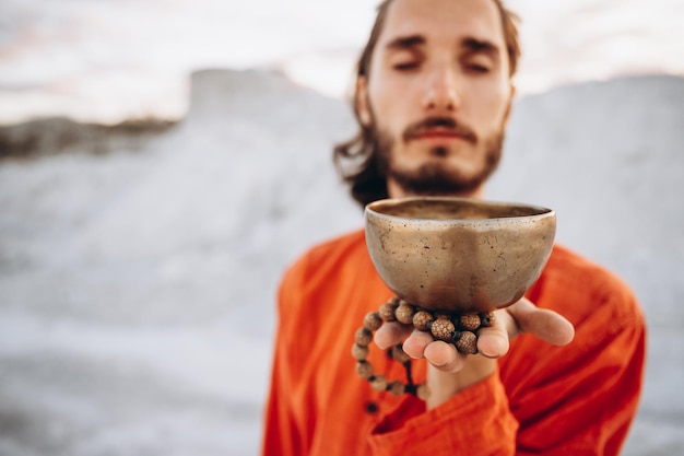 Authentic singing Tibetan bowls Portrait of a young stylish man with copper bowls in his hands