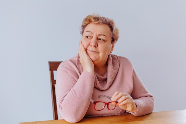 Authentiek portret van een oudere vrouw met een bril thuis een oudere vrouw thuis vastgelegd in een opvallende