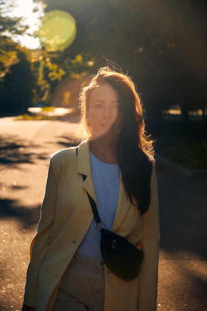 Authentiek portret van Oost-Europese duizendjarige vrouw in herfstpark tijdens zonsondergang