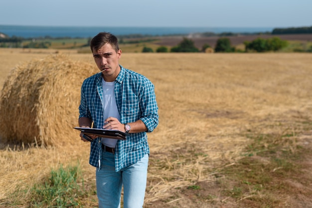 Authentiek voorportret van de agronoom van de jonge mensenboer in de hooiberg