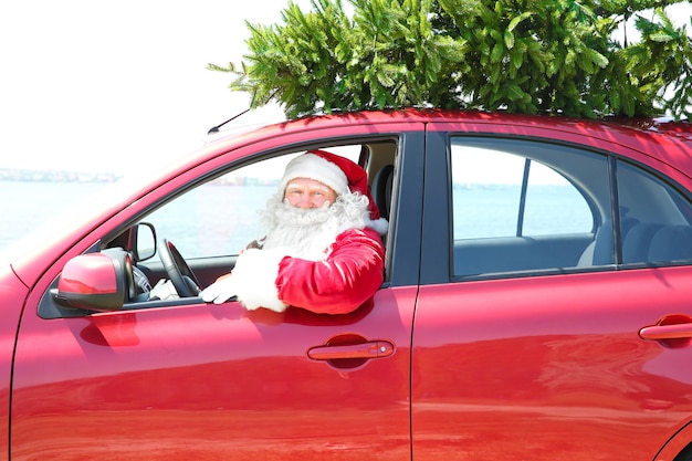 Authentieke kerstman rijdende auto met kerstboom erop