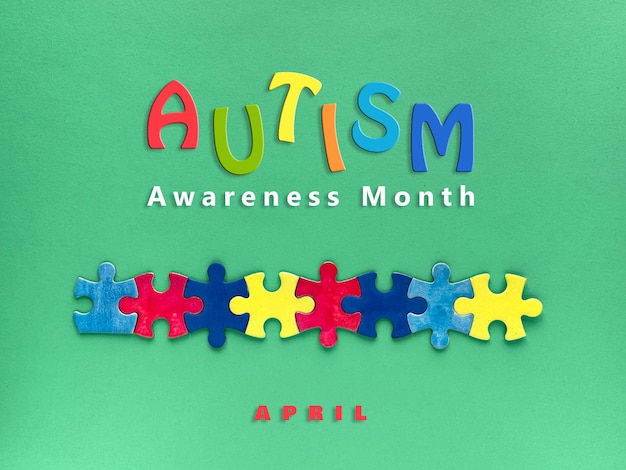 autism awareness month design with colorful puzzle pieces and text autism awareness month on green background