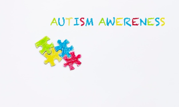 Testo di consapevolezza dell'autismo sfondo blu puzzle dipinti con pastelli