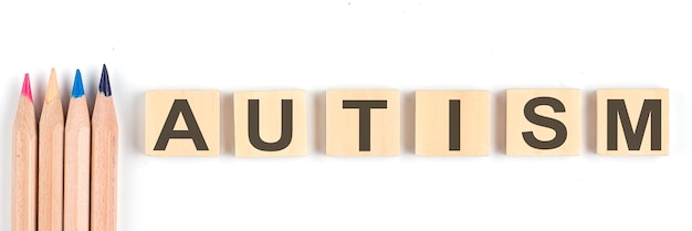 Autism concept - alphabet wood blocks on the white background with pencils