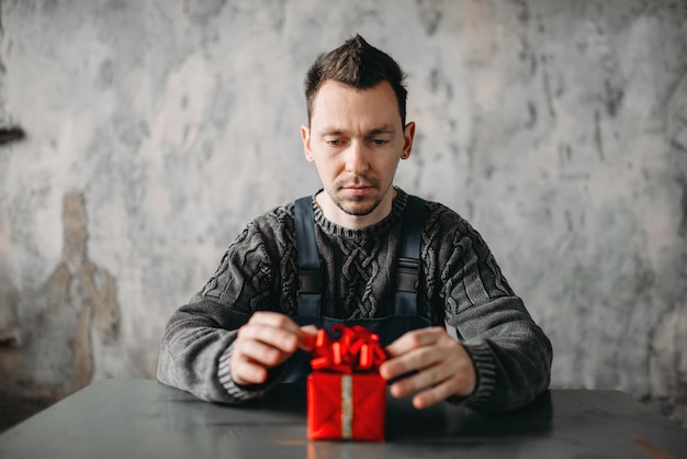 Photo autist man sitting against gift in wrapping paper