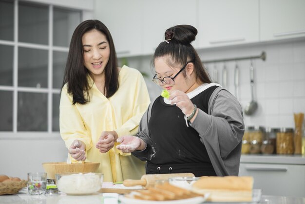 Autistisch meisje. Autistisch meisje oefent koken met haar moeder in de keuken.