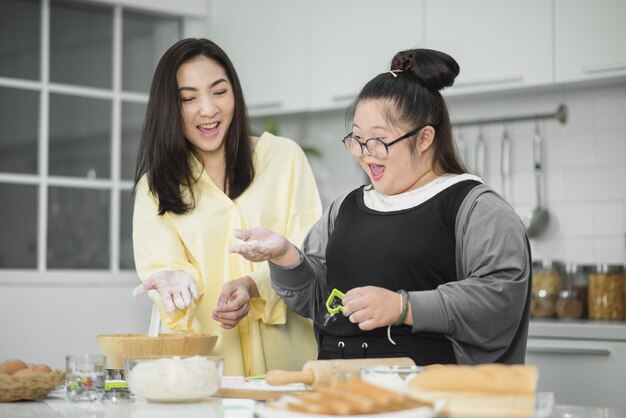 Autistisch meisje. Autistisch meisje oefent koken met haar moeder in de keuken.