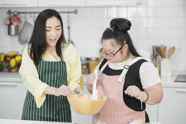 Autistisch meisje. Autistisch meisje oefent koken met haar moeder in de keuken.