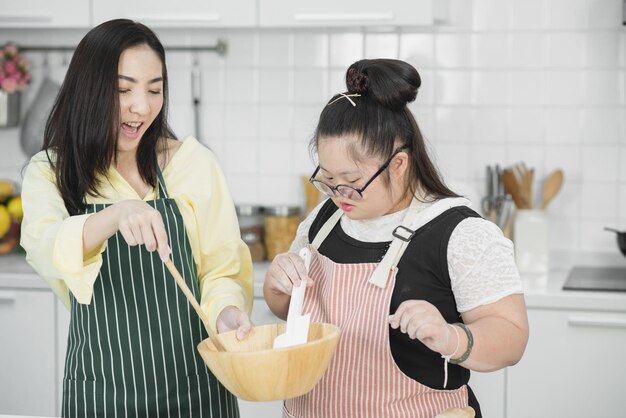 Autistisch meisje. Autistisch meisje oefent koken met haar moeder in de keuken.