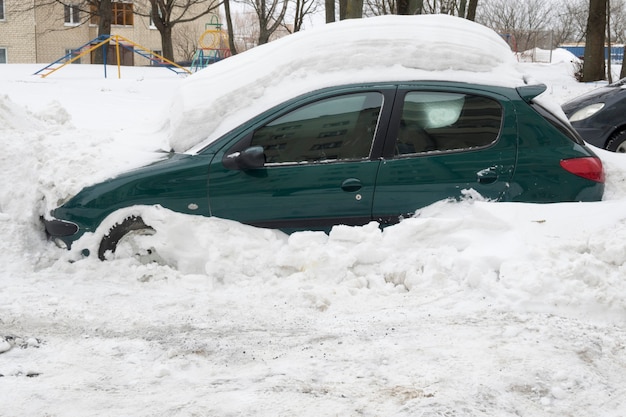 Auto bedekt met zware sneeuwjacht na zware wintersneeuwval