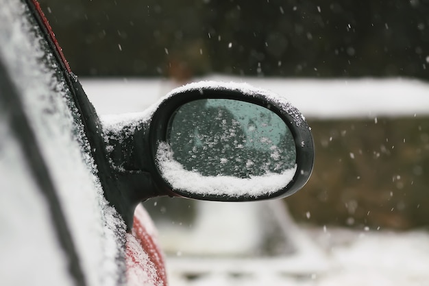 Auto buitenspiegel bedekt met verse natte sneeuw.