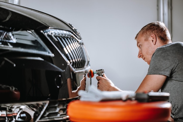 Foto auto detaillering concept van details en polijsten van auto's handen van een professionele auto service mannelijke werknemer