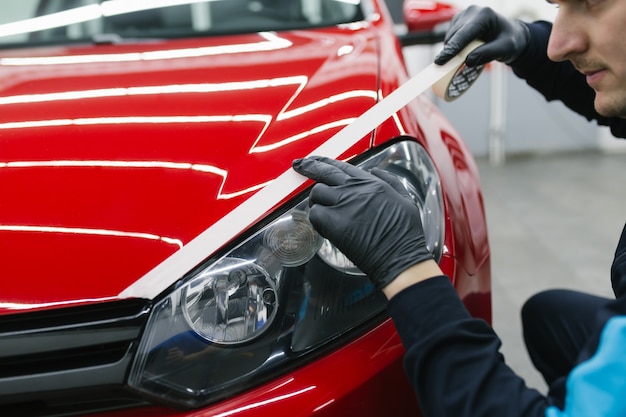 Auto detaillering - Man aan het werk in de winkel voor het polijsten van auto's. Selectieve aandacht.