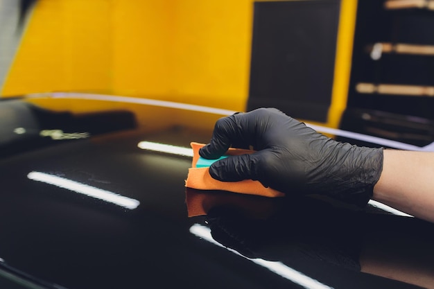 Auto-details Man past een nano-beschermende coating op de auto Selectieve focus