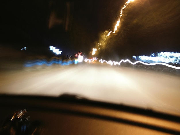 Foto auto die 's nachts op de weg rijdt