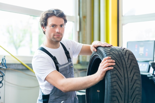 Photo auto mechanic changing tire in car workshop