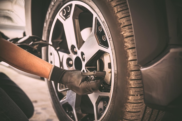 Auto mechanic checking air pressure and inflating car tires
concept of car care service and maintenance or fix the car leaky or
flat tire