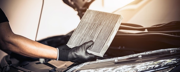 Auto mechanic checking cleaning and replacing car air filter Concept of car care service maintenance