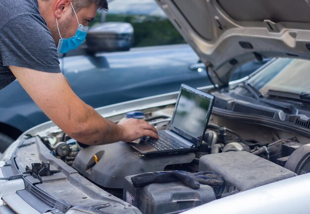 Foto meccanico auto che diagnostica auto meccanico auto che ripara un'auto