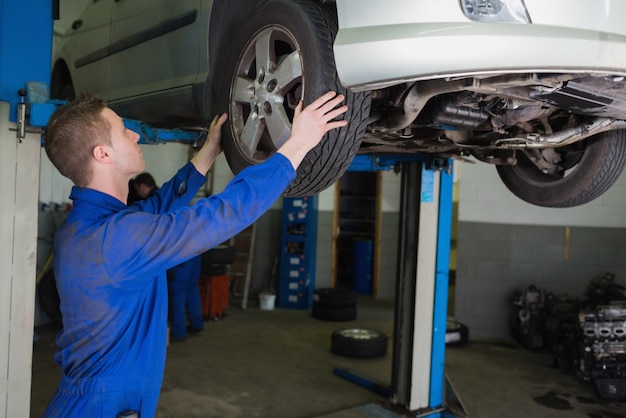 Auto mechanic examining car tire