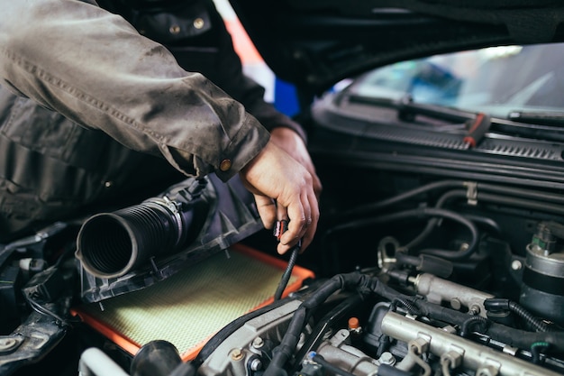 Auto mechanic repairing car. Selective focus.