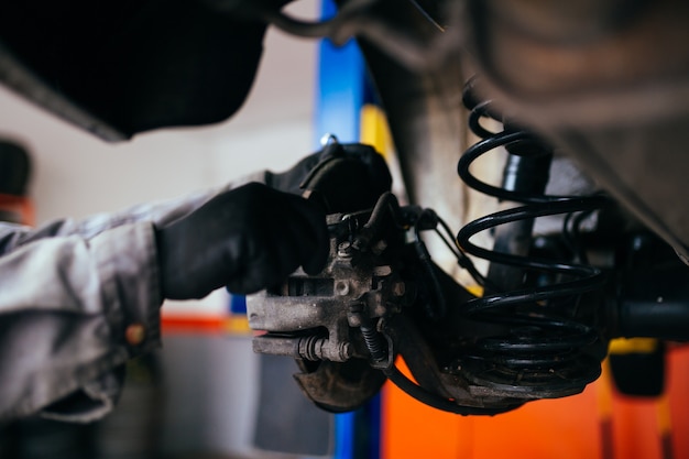 Auto mechanic repairing car. Selective focus.