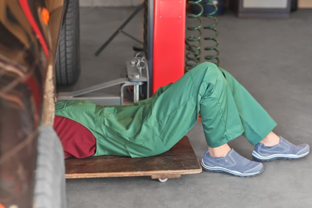 Auto mechanic repairing car in service center