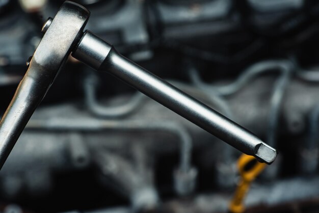 An auto mechanic repairs a car with a socket wrench Closeup Quality professional car repair Content for advertising