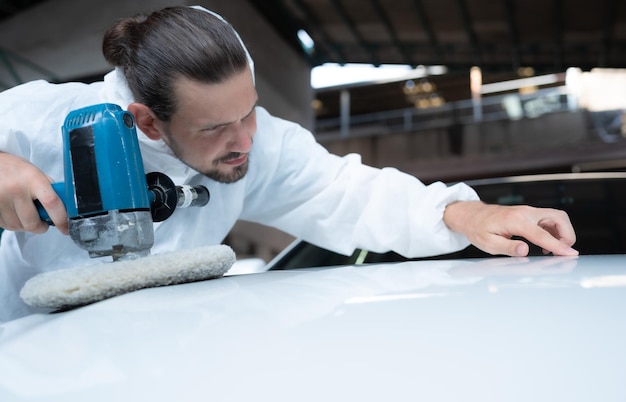 Auto mechanic use an electric polisher to polish the dried car paint After passing the paint from the car painting room