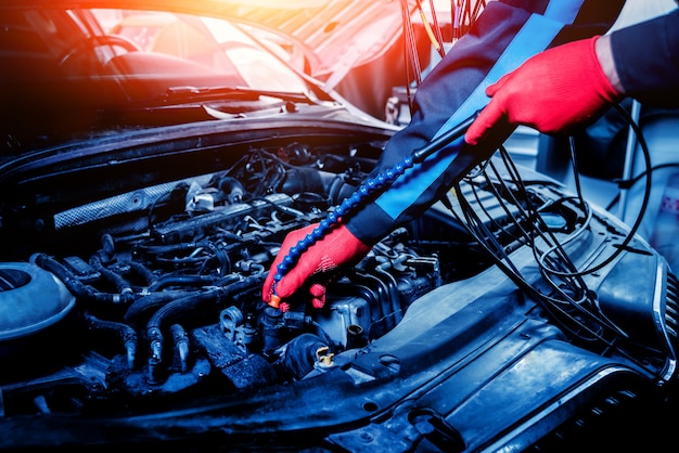 Auto mechanic uses a voltmeter to check the voltage level.