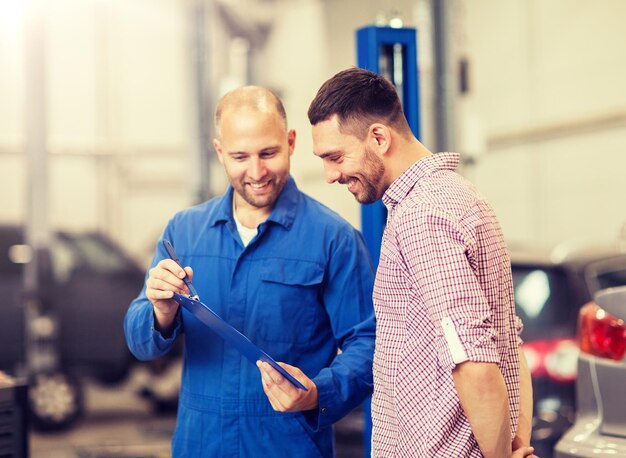 Photo auto mechanic with clipboard and man at car shop