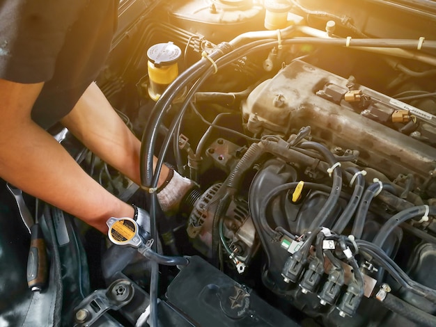 Photo auto mechanic with tool working check and fixed an old car engine at service station,change and repair before drive