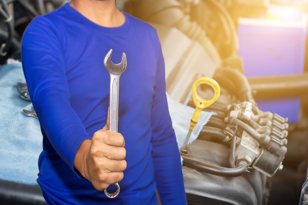 Foto meccanico automatico con controllo del funzionamento dell'utensile e riparazione di un vecchio motore di un'auto presso la stazione di servizio, sostituzione e riparazione prima della guida